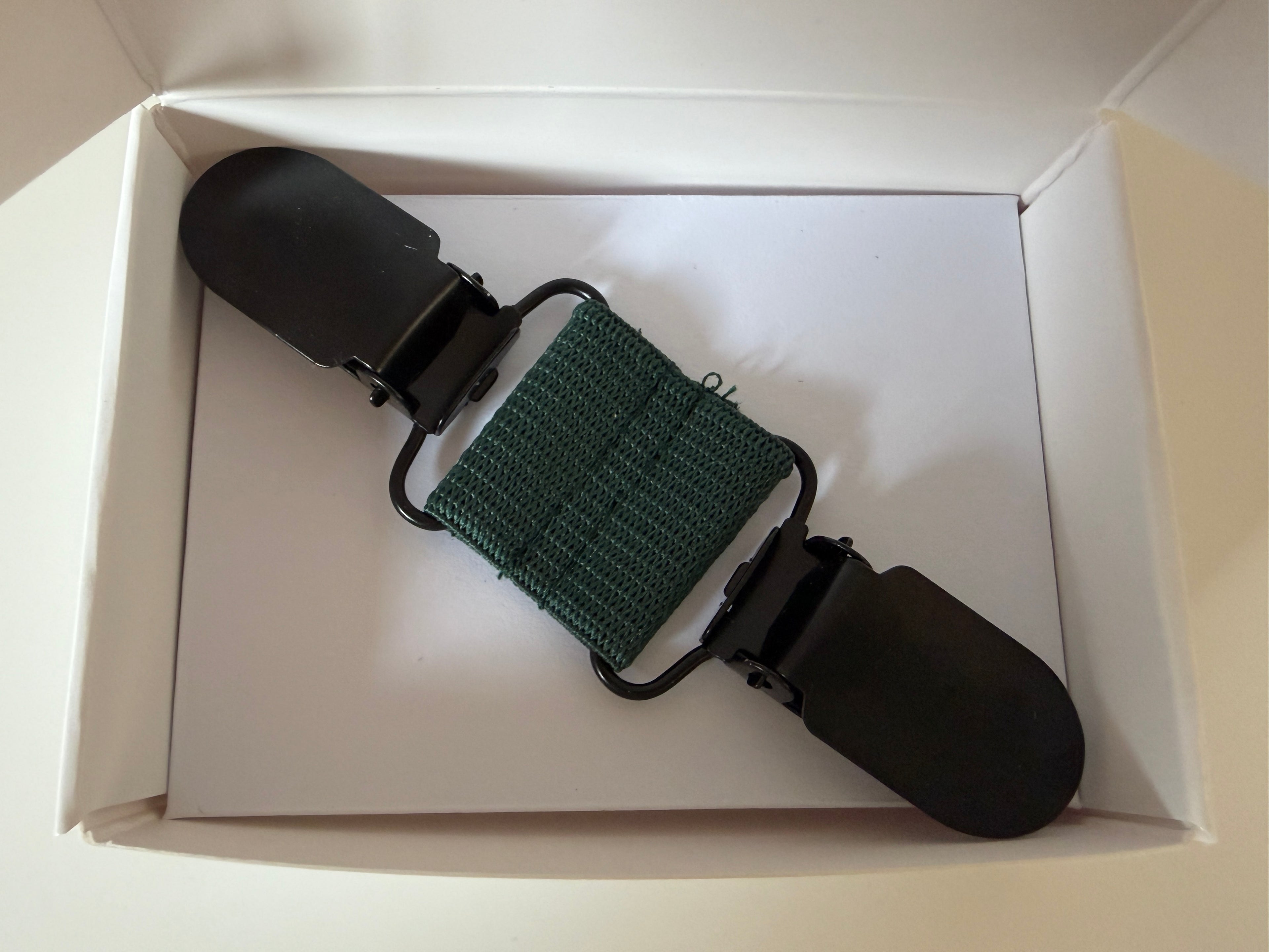 CapeAble – Schwarzer Clip mit grünem Elastik