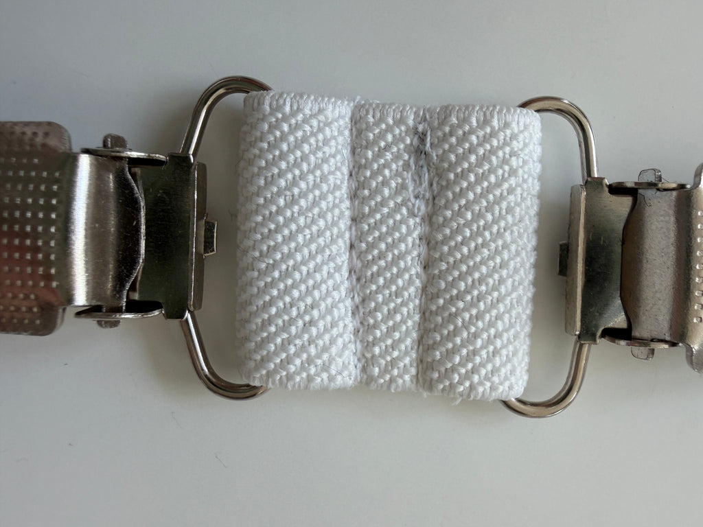 CapeAble - Silberner Clip mit weissem Elastik.